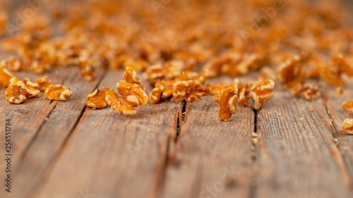 MACRO  DOF  Countless walnut kernels roll down the rustic wooden kitchen table.