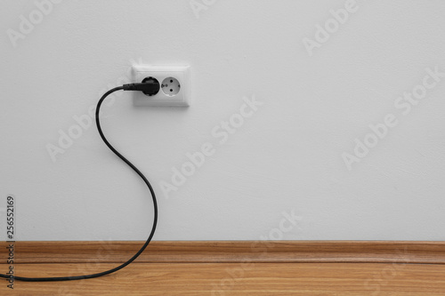 Power socket and plug on wall indoors, space for text. Electrician's equipment