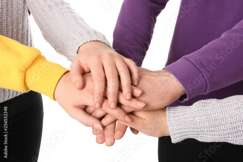 Group of people holding their hands together on white background, closeup © New Africa
