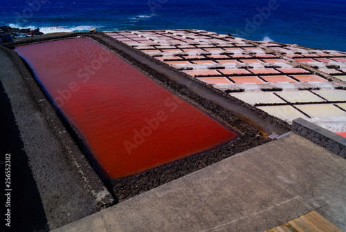 24 November 2018 La Palma Canary Islands, Salinas Marinas de Fuencaliente, Salts Flats and Mine showing multi coloured salt water fields aganst blue sky and waves photo