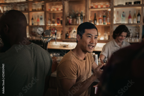 Young man talking with friends in a busy bar