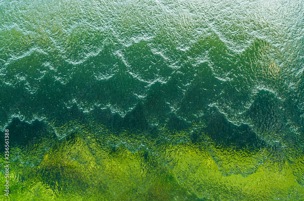 Wall of falling water on green and emerald background Wall of falling water on green and emerald background