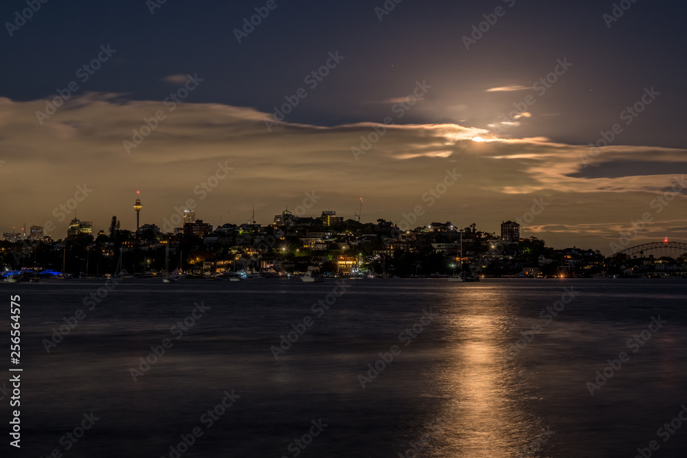 Night time moon behind clouds over Sydney Harbour Night time moon behind clouds over Sydney Harbour