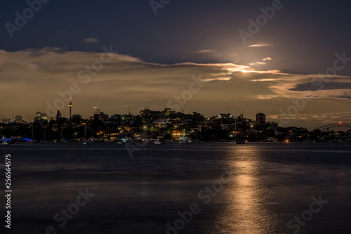 Night time moon behind clouds over Sydney Harbour