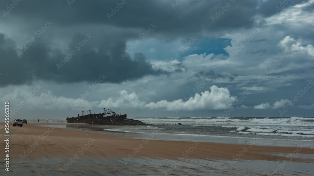 A shipwreck close to shore with stormy skies