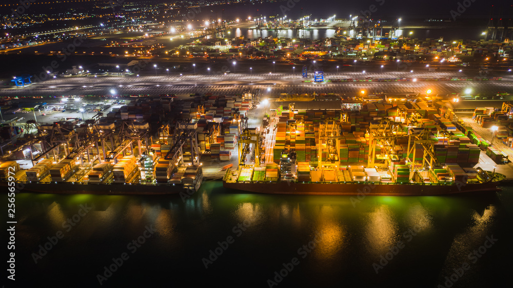 Fototapeta premium cargo loading station for international export and import by ship with containers open sea at night