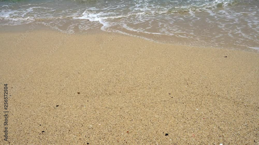 4K Video selective focus close up stabilize shot of soft sea wave splashing against the sand beach with bubble under sunlight in summer. 4K Video selective focus close up stabilize shot of soft sea wave splashing against the sand beach with bubble under sunlight in summer.