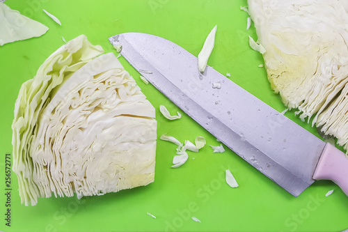 close up green plastic cutting board with 2 pieces of cabbage and vagetable