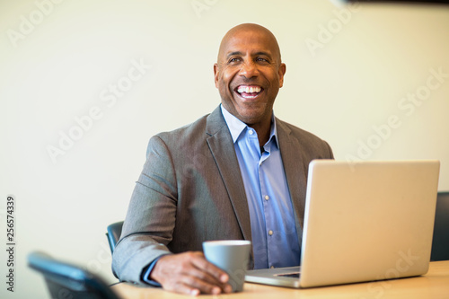 Happy mature African American man at work. photo