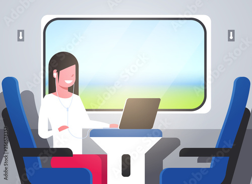 woman train passenger listening audio book with headphones tourist girl sitting blue armchair railway traveling concept female character portrait horizontal