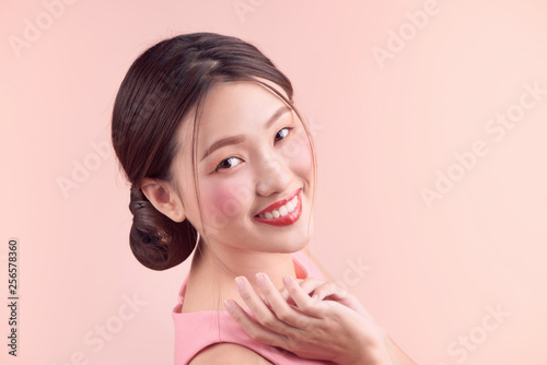 Beautiful asian girl with professional makeup and stylish hairstyle  isolated on pink. Cosmetics and make-up