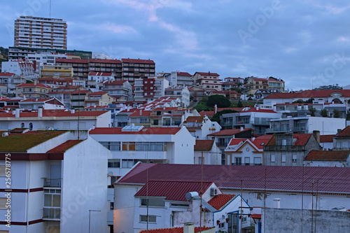 Stunning landscape view of vintage buildings with red tile roofs in the Portuguese resort of Nazare. Cloudy morning. Popular travel destination in Portugal