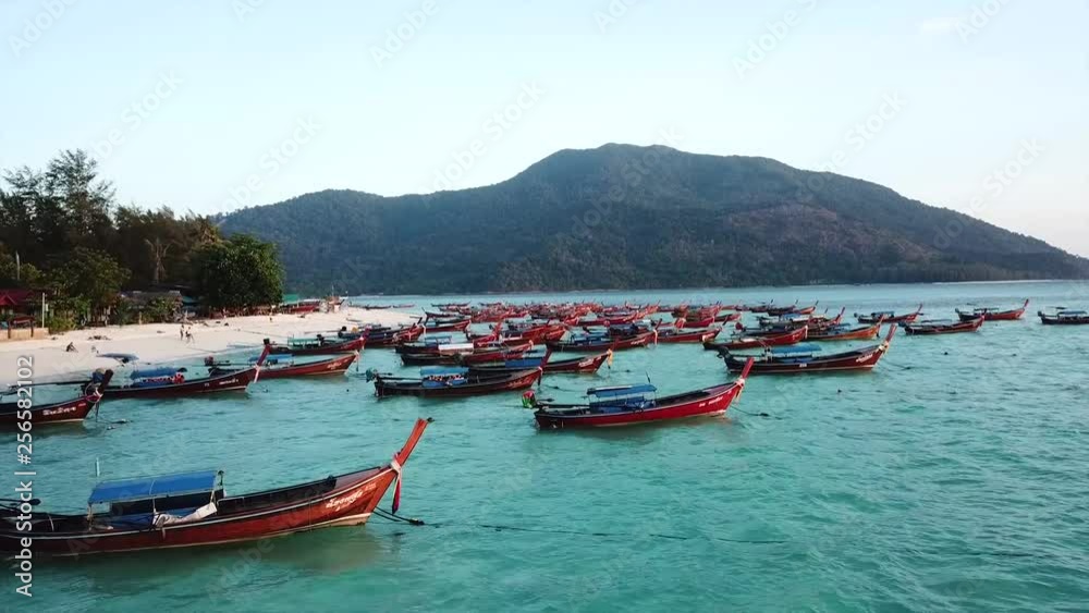Flying staight over traditional longtail boats, by a crystal clear beach, in Ko Lipe Island Thailand. Flying staight over traditional longtail boats, by a crystal clear beach, in Ko Lipe Island Thailand.