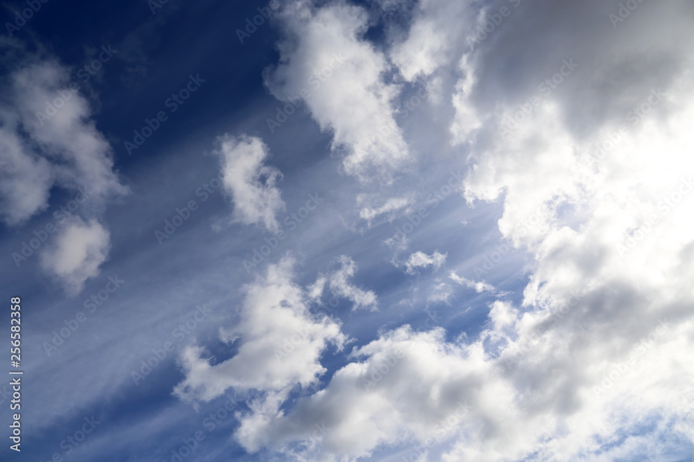 Obraz premium Sky covered with cumulus clouds after the storm. Spring cloudy sky with sun rays, beautiful background for weather