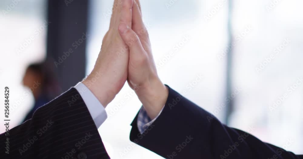 4K Close up on hands of successful business man & woman giving a high five. Slow motion.