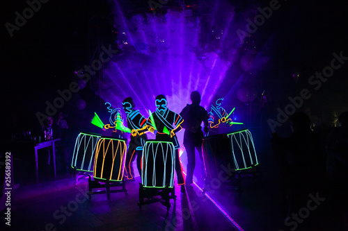 laser show performance, dancers in suits with LED lamp photo