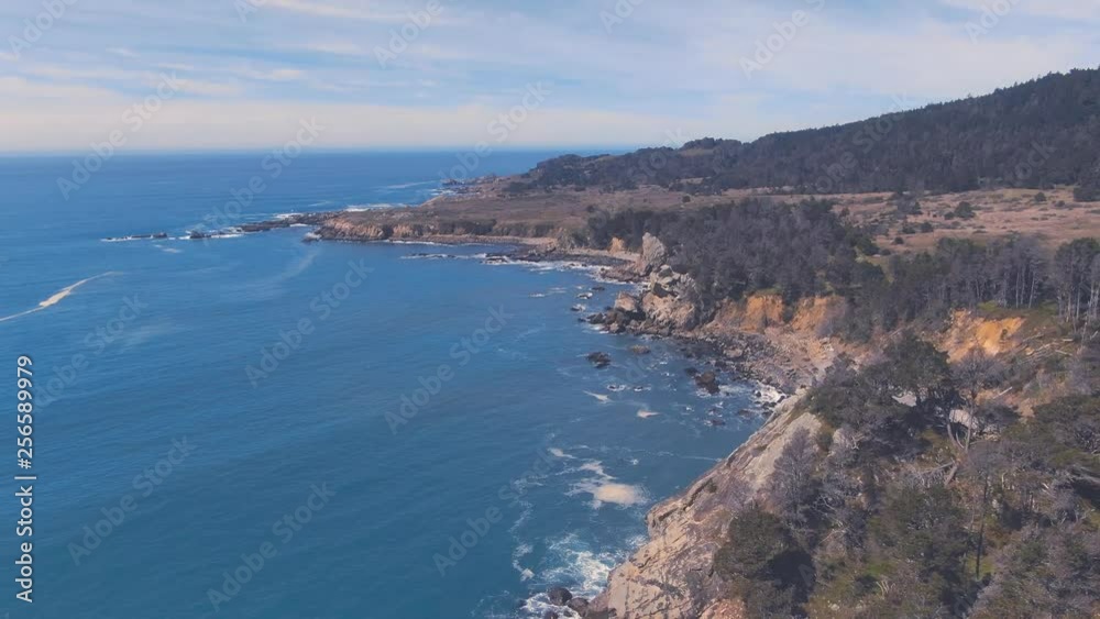 Sun drenched rocks are rhythmically beaten by Pacific Ocean Waves. Cliffs and rugged trees frame the seashore. Drone based aerial videography. Cinematic and beautiful. calming and Relaxed Euphoric Sun drenched rocks are rhythmically beaten by Pacific Ocean Waves. Cliffs and rugged trees frame the seashore. Drone based aerial videography. Cinematic and beautiful. calming and Relaxed Euphoric