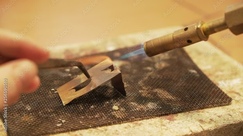 Soldering metal plates with butane gas flame burner - close up shot in slow motion Soldering metal plates with butane gas flame burner - close up shot in slow motion