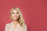 Young happy blonde woman looking up portrait. Cute girl face on pink background