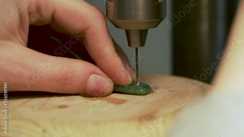 Close up of drilling hole into greenstone from New Zealand and cooling drill with water on tooth brush photo