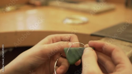 Close-up shot of fixing greenstone from New Zealand with silver wire - jewelry making photo