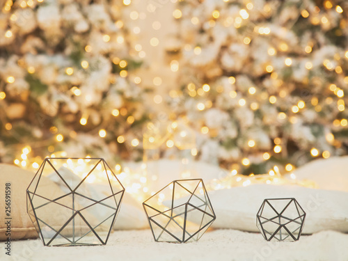 Glass icosahedrons  near christmas tree with lights. Abstract geometric shape of glass. photo