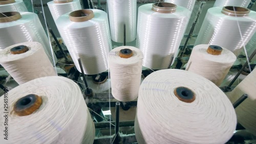 Yarn spools on spinning machines at a textile plant. photo