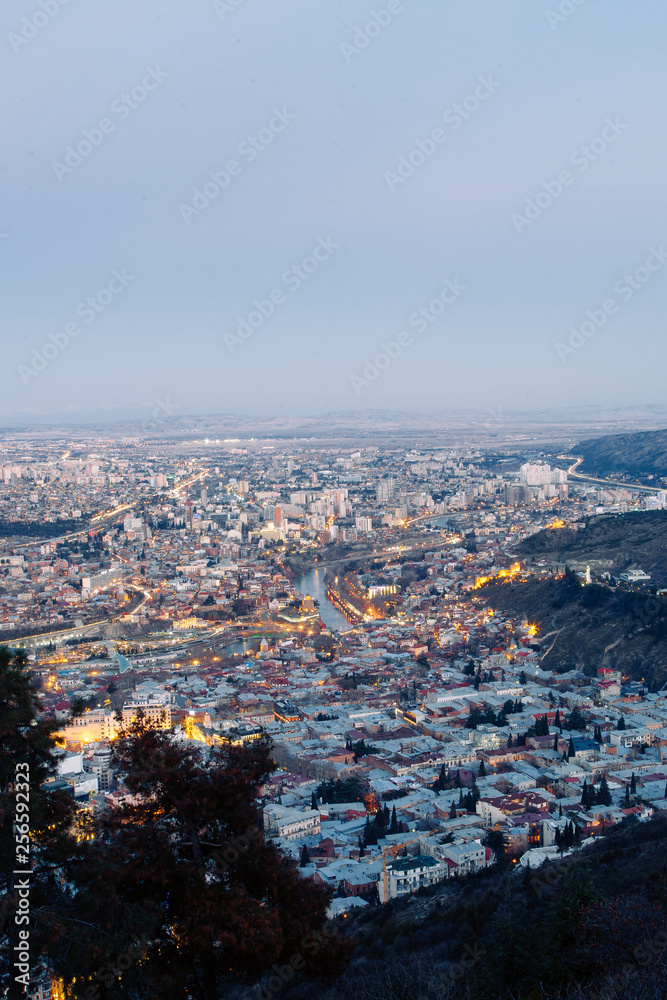 Sunset and evening city Tbilisi, Georgia. Panoramic views and lights of historic neighborhoods.