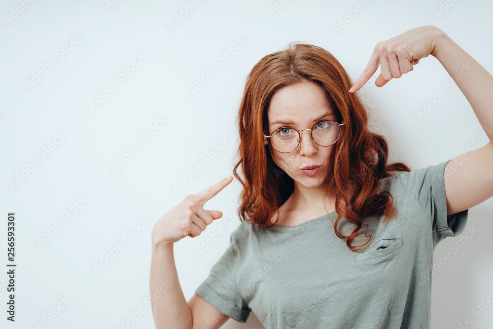 Cute extrovert young woman pointing at herself Cute extrovert young woman pointing at herself