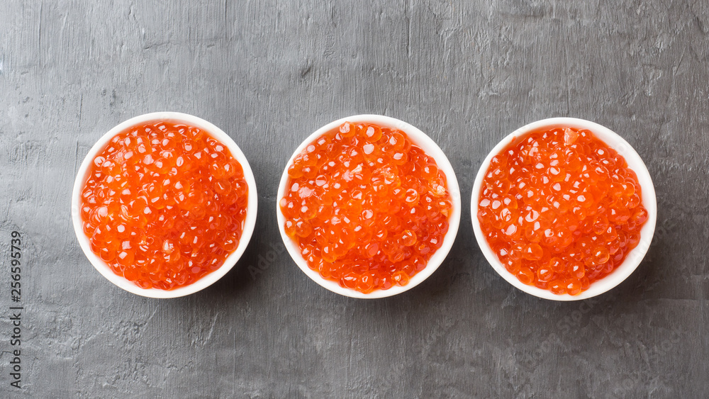 red salmon caviar in a plate on a dark table. red salmon caviar in a plate on a dark table.