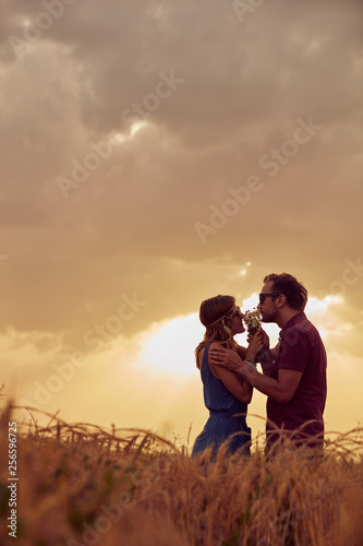 Couple in sunset / sunrise time in a wheat field.