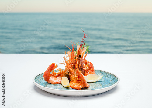 Shrimps on a plate against the background of the sea