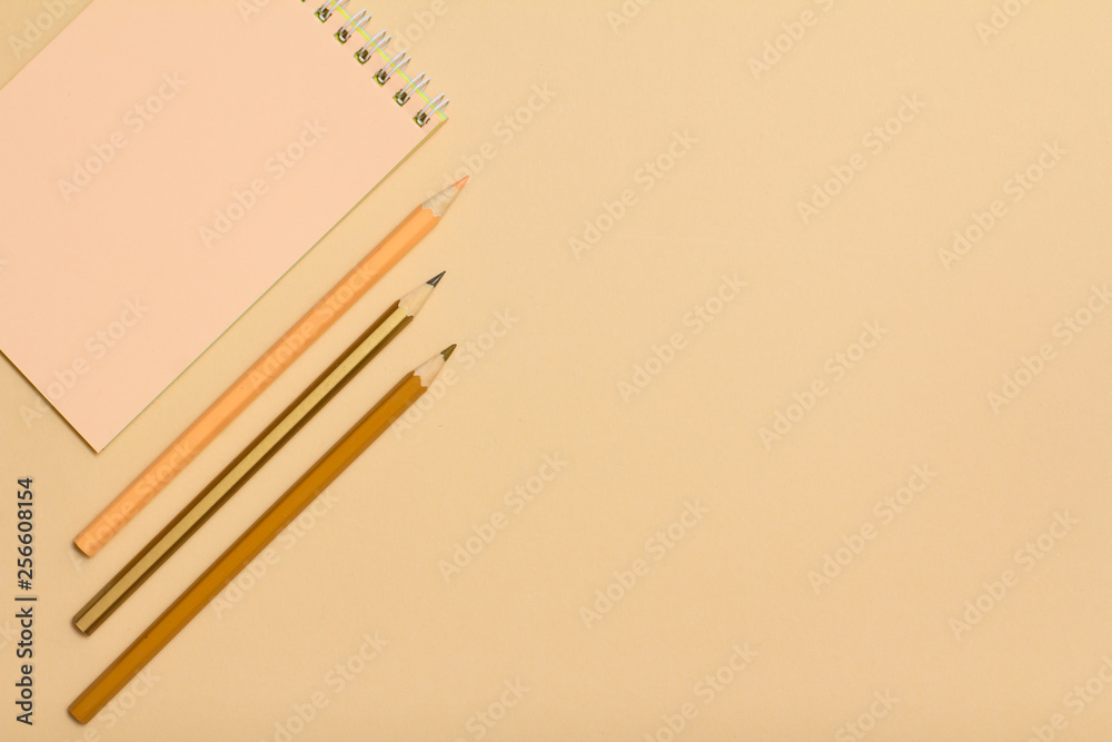 School supplies. Notebook and color pencils on beige background. School supplies. Notebook and color pencils on beige background.
