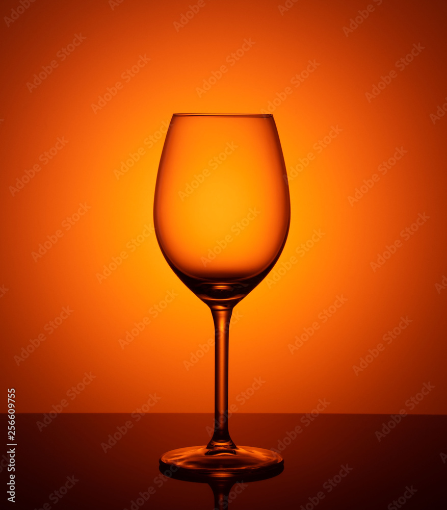 empty glass goblet on orange background