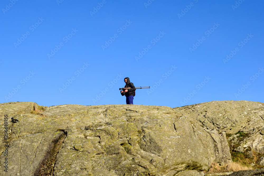 Photographer with a tripod in the mountains on a beautiful sunny day. Rogaland. Norway.