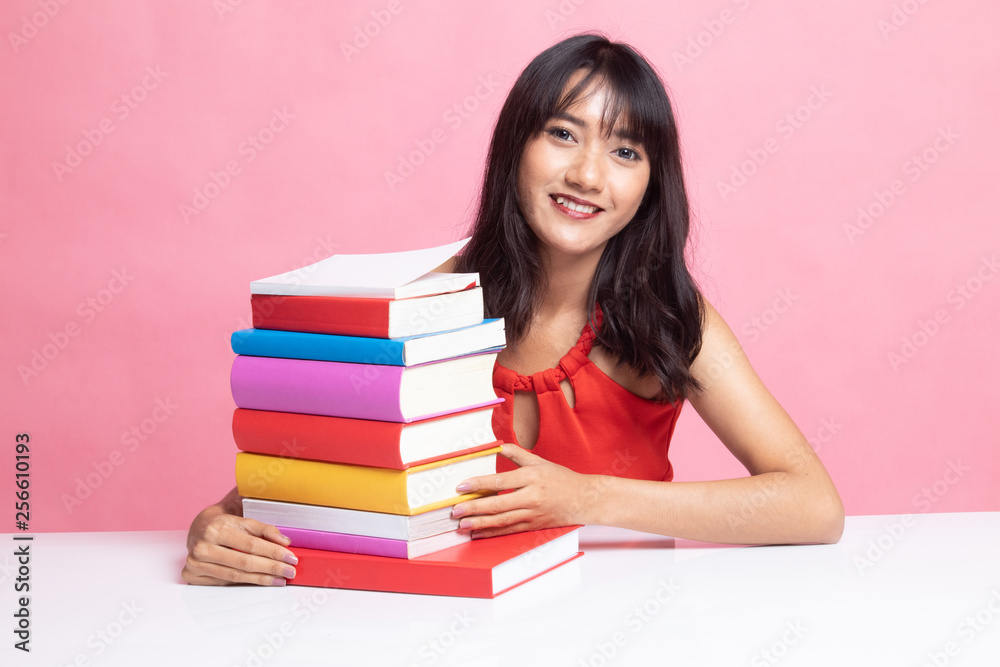 Happy young Asian woman read a book with books on table. Happy young Asian woman read a book with books on table.
