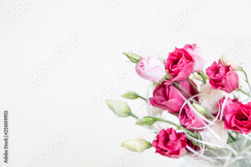 Bouquet of red Eustoma flowers in vase on white background © glebchik