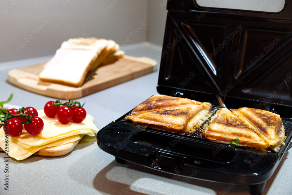 Ταπετσαρία Open black sandwich maker with toasted sandwiches on kitchen counter, fresh ingr