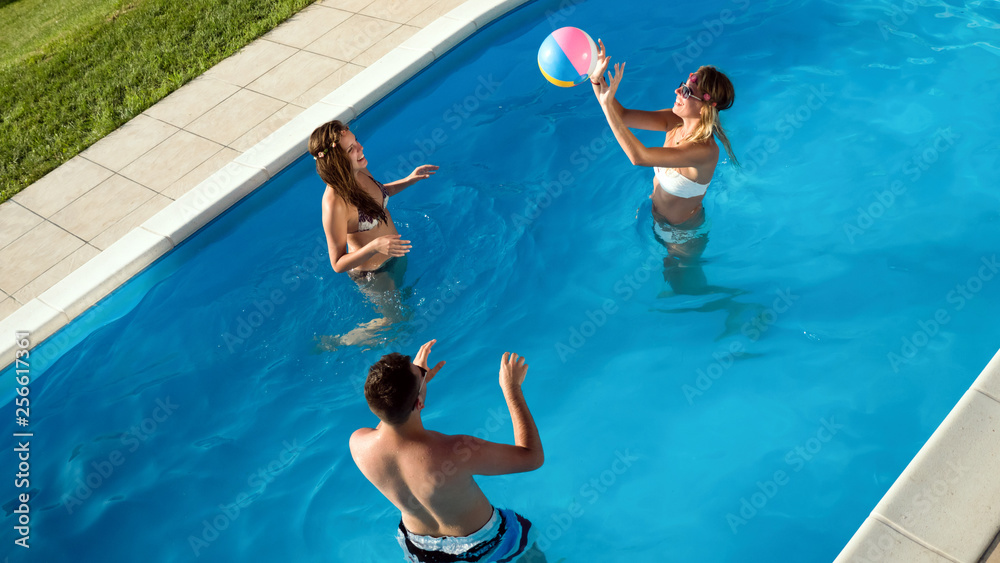 Friends playing ball games in pool