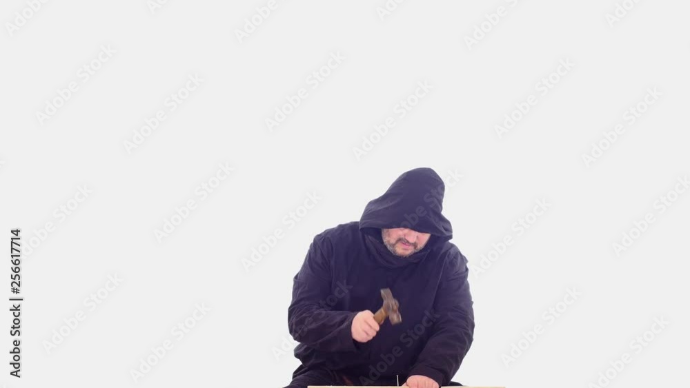 medieval man in hoodie hammering nail white screen medieval man in hoodie hammering nail white screen