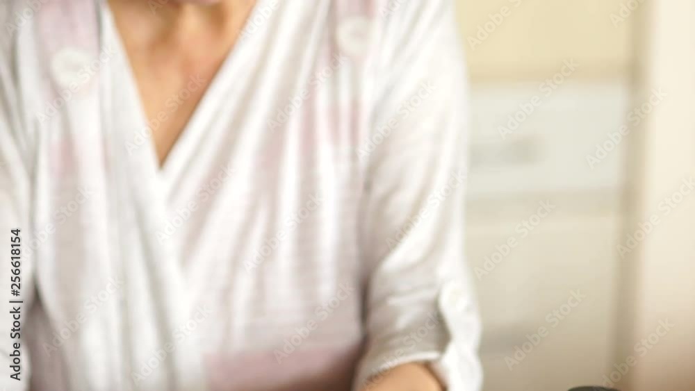 Retiree washes down a tablet with water from a glass. Pharmacy concept. Hands of an old woman on the background of bottles and blisters with pills Retiree washes down a tablet with water from a glass. Pharmacy concept. Hands of an old woman on the background of bottles and blisters with pills