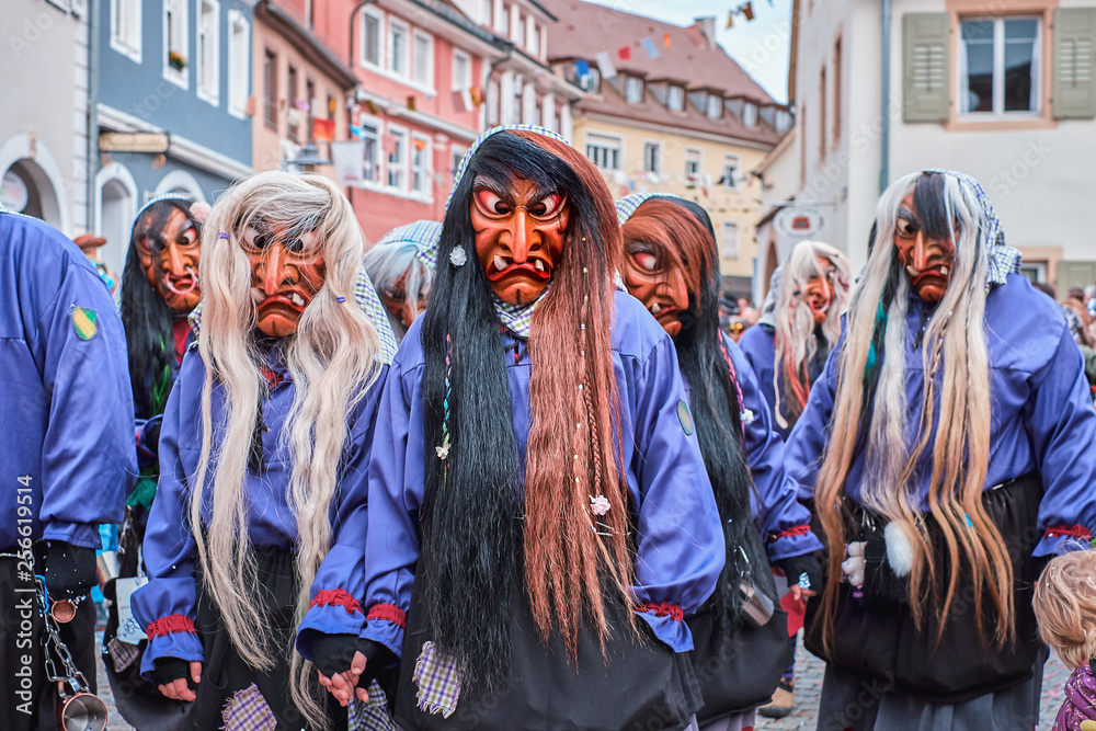 Group of witches in violet black robes. Street Carnival in Southern Germany - Black Forest.