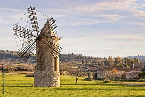 Windmill in montuiri, farm, meadow,trees and beautiful hills, mallorca, spain.