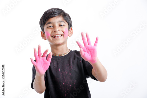 Indian little boy playing with the color and giving multiple expressions in holi festival 