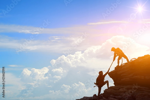 Foto Climbing team are on the climb to the cliff,hiking and team work concept