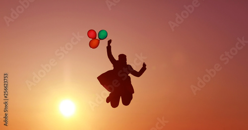girl flies with balloons at sunset, multi-colored balloons, incredible sky sunset, flying into the sky