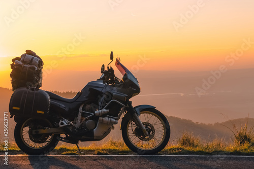 Adventure motorcycle  silhouette touristic motorbike. the mountain peaks in the dark colors of the sunset. Copy space. Concept of Tourism  adventures  active lifestyle  Transfagarasan  Romania