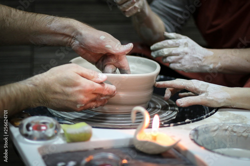 Hands of a Potter creating the clay.  Vessel on the Potter s wheel.