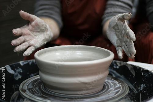 Hands of a Potter creating the clay. Vessel on the Potter's wheel.