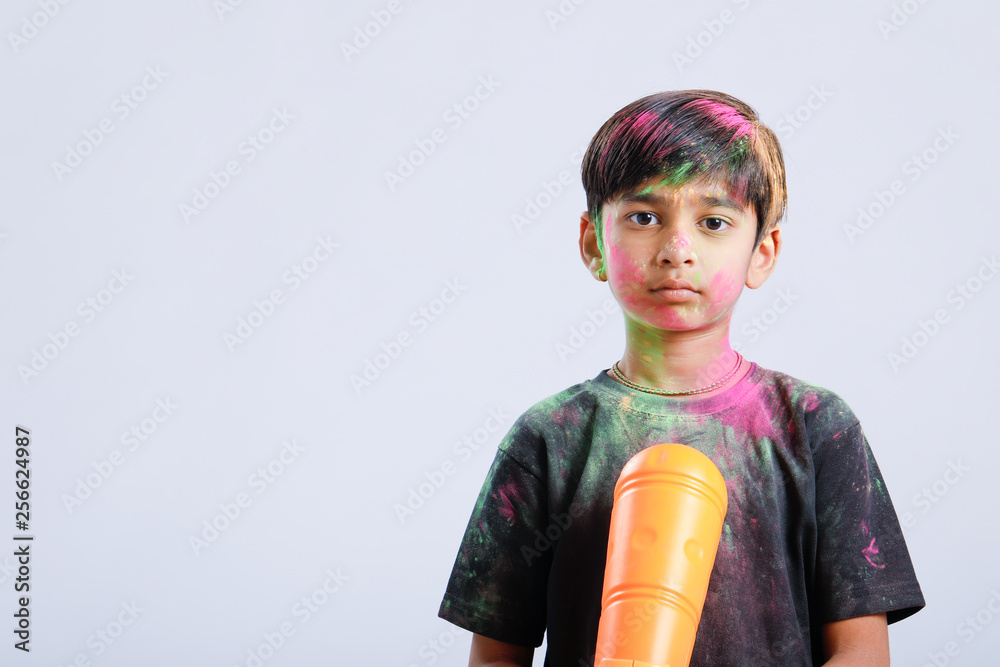 Indian Child playing holi with color gun Indian Child playing holi with color gun